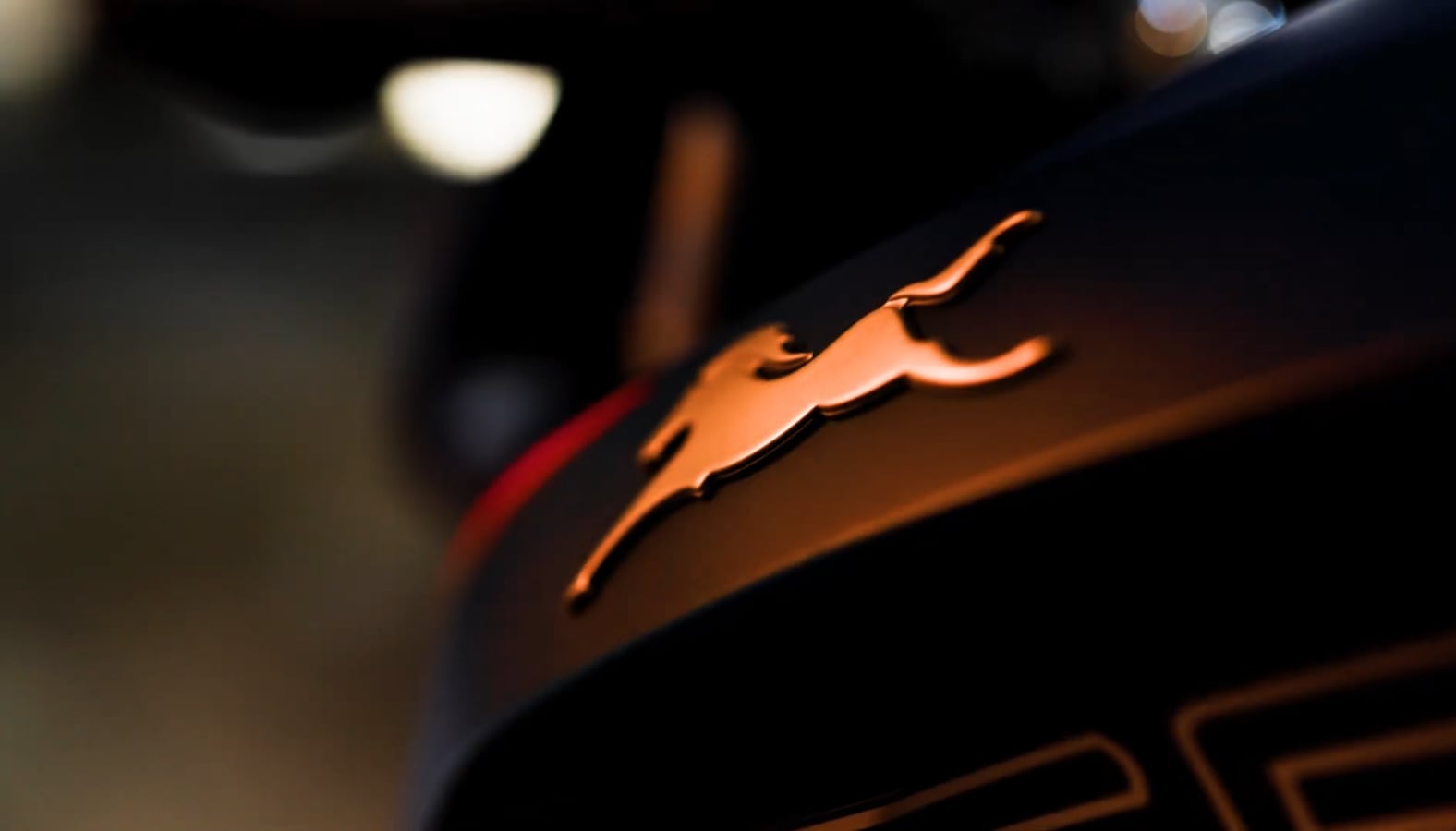 Still from Bike Showcase: a glowing emblem on a motorcycle tank in the dark